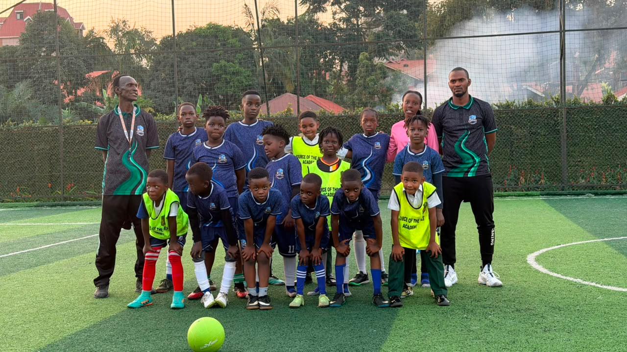 Source of Nile Academy squad in blue kit with coaching staff on a floodlit training pitch