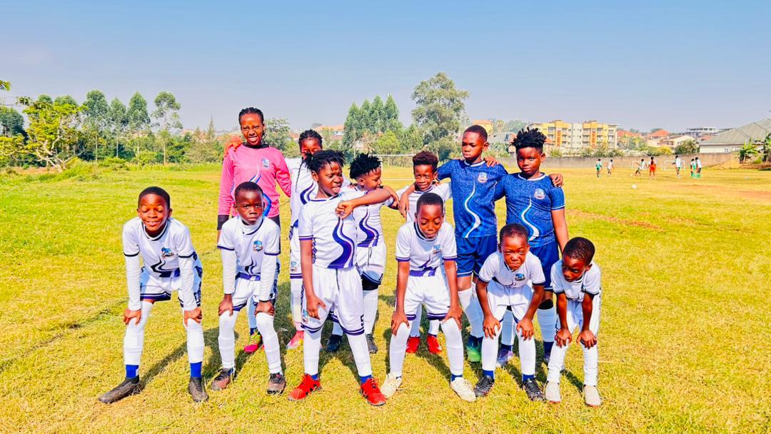 Source of Nile Academy squad in white and blue kits with their coach on a pitch in Uganda